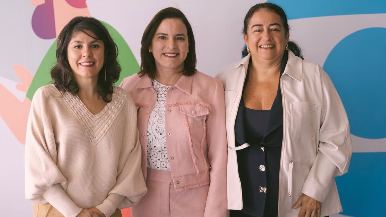 A primeira-dama Cristiane Leitão e a coordenadora da Primeira Infância, Lidia Lourinho, posam para foto junto com participante do encontro